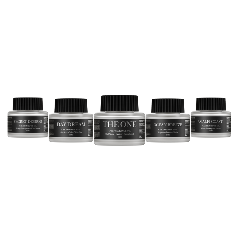 Five car fragrance oil bottles labeled 'Day Dream', 'The One', 'Secret Desires', 'Amalfi Coast' and 'Ocean Breeze'  on a white background.