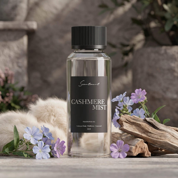 Scentiment Cashmere Mist diffuser fragrance oil bottle with cashmere, flowers, and sandalwood sticks.
