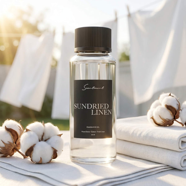 Scentiment Sundried Linen diffuser fragrance oil bottle with cotton flowers and linen fabric in the background.