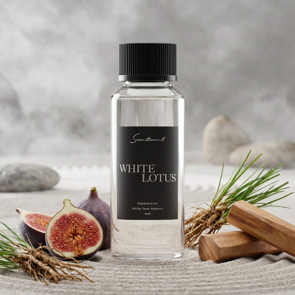 Scentiment White Lotus diffuser fragrance oil bottle with figs and grass on a textured sand surface.